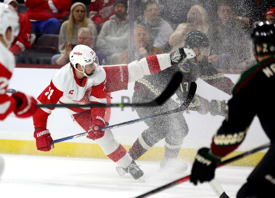 Red Wings center Dylan Larkin loses his balance battling for the puck against Coyotes center Nick Bjugstad during the first period on Tuesday, Jan. 17, 2023, in Tempe, Arizona.