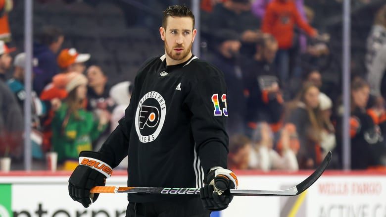 Kevin Hayes of the Philadelphia Flyers, number 13, wearing the team's Pride-themed jersey, looks on.