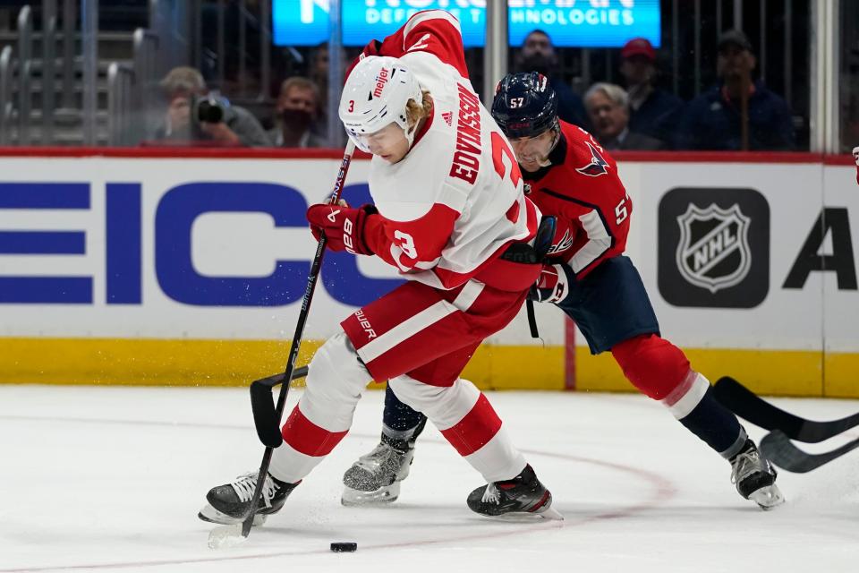 Detroit Red Wings defenseman Simon Edvinsson (3) and Washington Capitals defenseman Trevor van Riemsdyk (57) compete for the puck during the first period of a preseason NHL hockey game Wednesday, Oct. 5, 2022, in Washington.