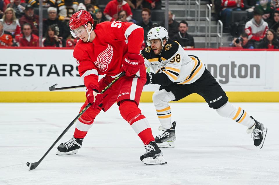 Detroit Red Wings defenseman Moritz Seider scores a goal as Boston Bruins right wing David Pastrnak defends during the second period at Little Caesars Arena, March 12, 2023.