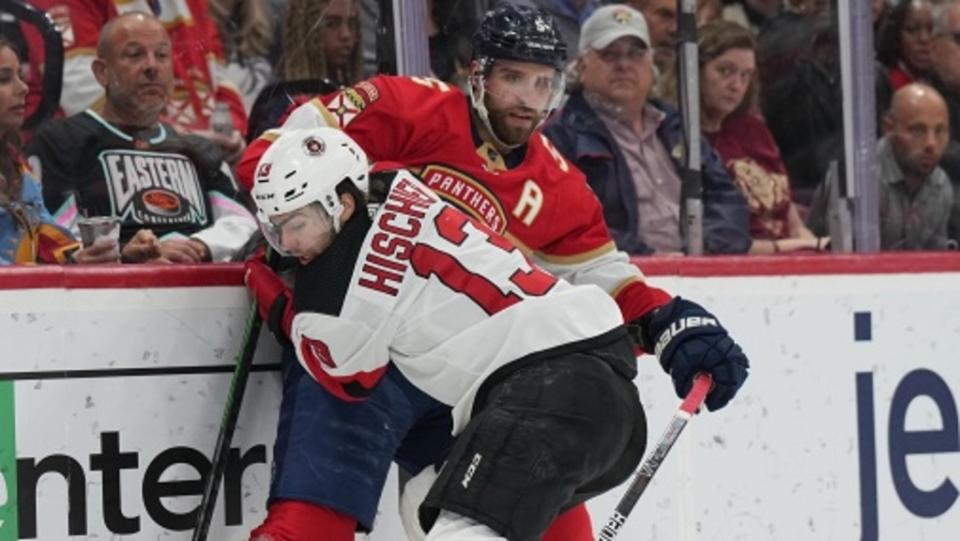 New Jersey Devils center Nico Hischier (13) and Florida Panthers defenseman Aaron Ekblad (5) battle for a loose puck in the first period at FLA Live Arena