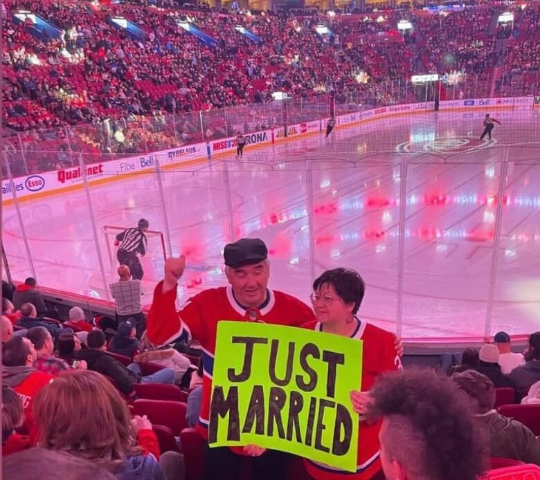 Moose-Cree couple hold up a "Just Married" sign during a Montreal Canadians hockey game.