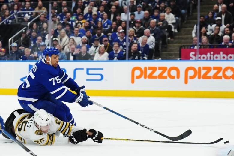 Toronto Maple Leafs' Ryan Reaves (75) is checked by Boston Bruins' Brandon Carlo (25) during second period action in Game 3 of an NHL hockey Stanley Cup first-round playoff series in Toronto on Wednesday, April 24, 2024. THE CANADIAN PRESS/Nathan Denette