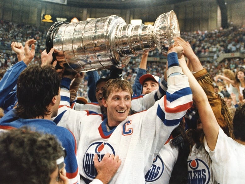 Wayne Gretzky lifting the Stanley Cup above his head.