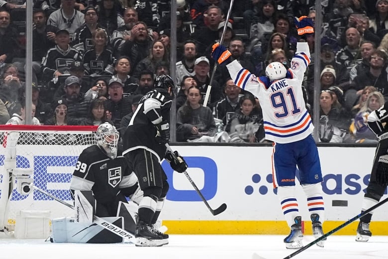 A hockey player sticks his arms up in the air, celebrating a goal scored.