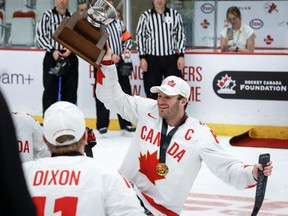 Team Canada forward Tyler McGregor (8) holds the trophy after defeating Team USA to win the World Para Ice Hockey Championship final in Calgary