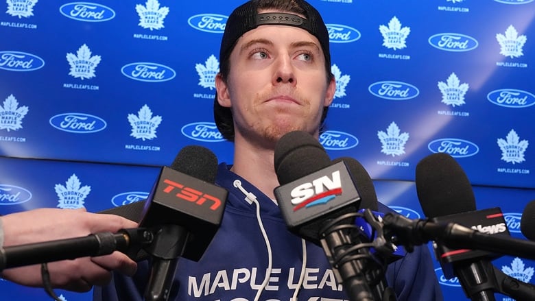 An NHL player, dressed in Maple Leafs hoodie and wearing a ball cap backwards, addresses reporters on May 6, 2024, two days after his team's season-ending loss to Boston Bruins in the first round of the Stanley Cup playoffs.