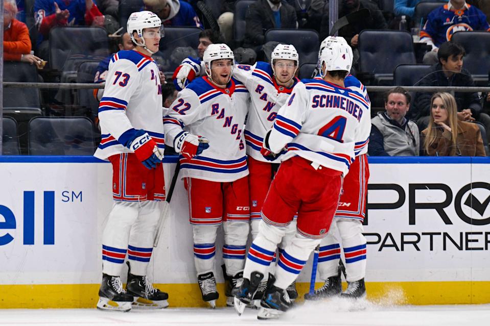 New York Rangers center Jonny Brodzinski (22) celebrates a goal against the New York Islanders with center Matt Rempe (73), defenseman Braden Schneider (4) and defenseman Urho Vaakanainen (18) during the first period at UBS Arena. © Dennis Schneidler-Imagn Images