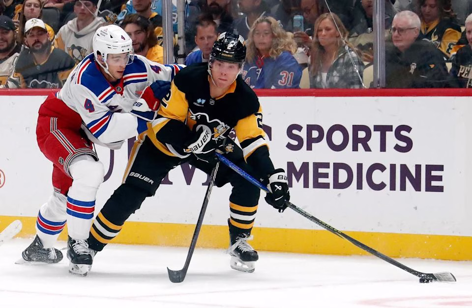 Oct 9, 2024; Pittsburgh, Pennsylvania, USA; Pittsburgh Penguins right wing Rutger McGroarty (2) moves the puck against New York Rangers defenseman Braden Schneider (4) during the first period at PPG Paints Arena. (Charles LeClaire-Imagn Images)